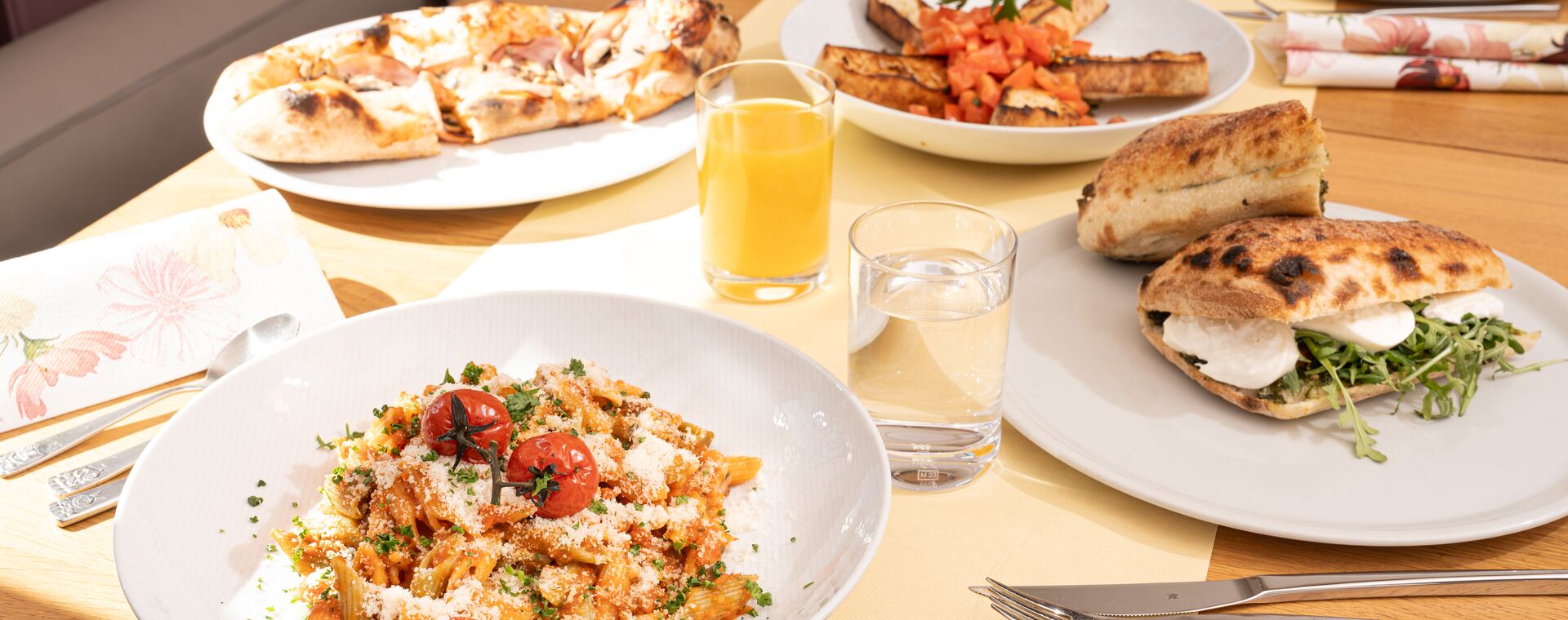 buntes Essen im Bootshus mit Nudeln, belegtes Baguette und Pizza